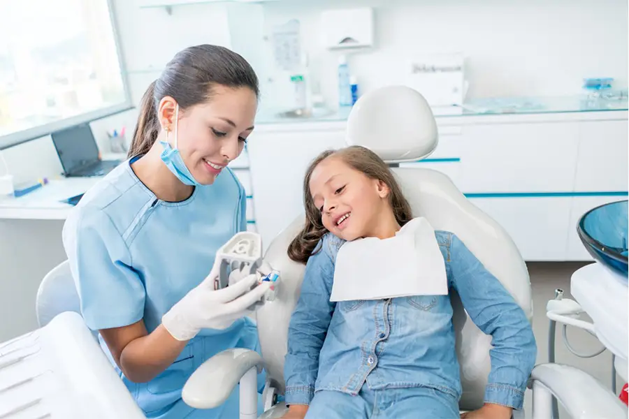 A child receiving treatment in the Bicester Dental practise. Both the dentist and the child look happy.